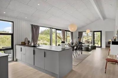 a kitchen and living room with a lot of windows at BL1411-Blokhus-Ribergaardsvej-15 in Blokhus