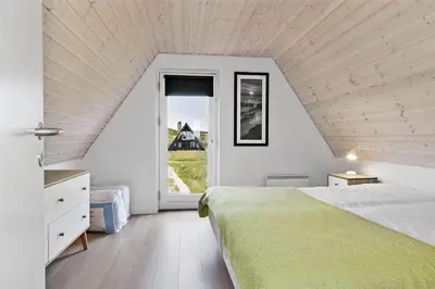 a bedroom with a large bed and a window at BL1193-Pandrup-Narhvalen-14 in Pandrup