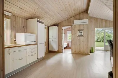 a large kitchen with white appliances and wooden walls at BL1345-Blokhus-Berberisvej-59 in Blokhus
