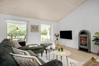 a living room with a couch and a tv at BL1345-Blokhus-Berberisvej-59 in Blokhus