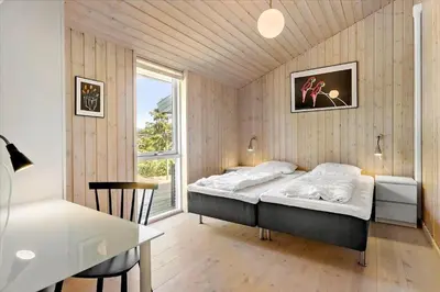 a bedroom with a bed and a table and a window at BL540-Saltum-Trehoje-9 in Saltum