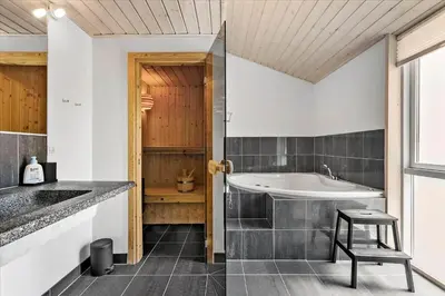 a bathroom with a tub and a sink and a stool at BL540-Saltum-Trehoje-9 in Saltum