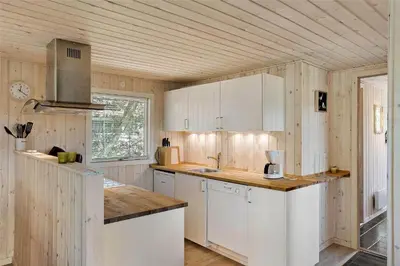 a kitchen with white cabinets and a wooden ceiling at BL1066-Pandrup-Rodhus-Skolevej-17 in Pandrup