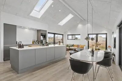 a kitchen and living room with a table and chairs at BL1427-Blokhus-Ovesensvej-9 in Blokhus