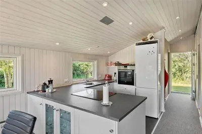 a kitchen with white cabinets and a black counter top at BL1625-Saltum-Fladen-Grund-8 in Saltum
