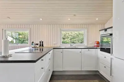 a kitchen with white cabinets and a black counter top at BL1625-Saltum-Fladen-Grund-8 in Saltum