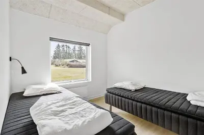two beds in a room with a window at BL1169-Blokhus-Berberisvej-5 in Blokhus