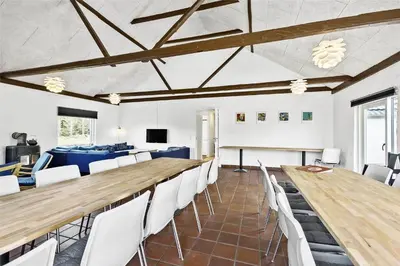 a conference room with a long table and white chairs at BL1169-Blokhus-Berberisvej-5 in Blokhus