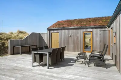 a patio with a table and chairs and a building at BL1350-Blokhus-Taarnfalkevej-29 in Blokhus