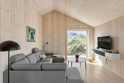 a living room with a couch and a table at BL1350-Blokhus-Taarnfalkevej-29 in Blokhus