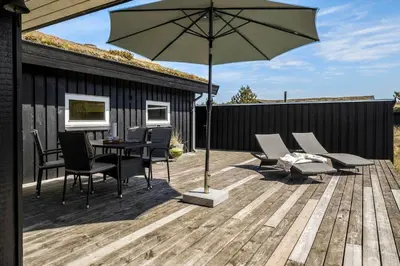 a patio with an umbrella and a table and chairs at BL112-Saltum-Kvansletten-20 in Saltum