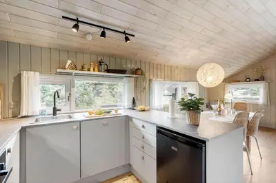 a kitchen with white cabinets and a black dishwasher at BL1254-Pandrup-Rodhusparken-25 in Pandrup