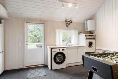 a kitchen with a washing machine and a washer and dryer at BL1254-Pandrup-Rodhusparken-25 in Pandrup