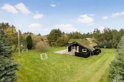a house with a green roof on a grass field at BL1254-Pandrup-Rodhusparken-25 in Pandrup