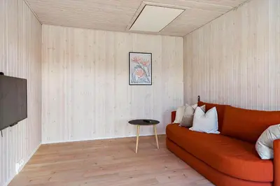 a living room with a orange couch and a table at BL1502-Blokhus-Graevlingevej-3 in Blokhus