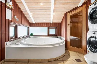 a large bathroom with a tub and a washing machine at BL1203-Blokhus-Pirupshvarrevej-23 in Blokhus