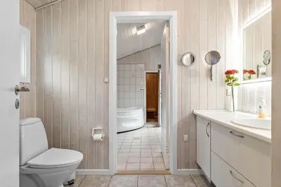 a white bathroom with a toilet and a sink at BL180-Blokhus-Soren-Petersvej-22 in Blokhus