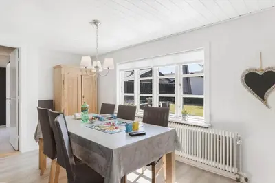 a dining room with a table with chairs and a heart on the wall at BL1496-Blokhus-Peder-Madsensvej-28 in Blokhus