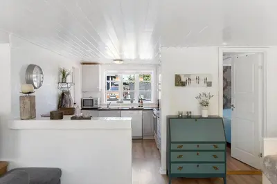 a kitchen with white walls and a blue cabinet at BL1496-Blokhus-Peder-Madsensvej-28 in Blokhus