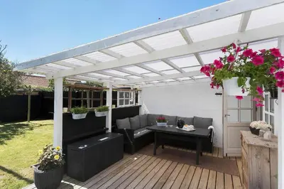 a white pergola on a deck with a table at BL1496-Blokhus-Peder-Madsensvej-28 in Blokhus