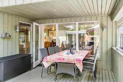 a table and chairs on a screened in porch at BL721-Pandrup-Rodhus-Skolevej-32 in Pandrup