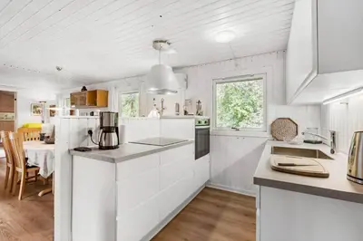 a white kitchen with white cabinets and a table at BL721-Pandrup-Rodhus-Skolevej-32 in Pandrup