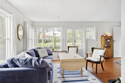a living room with a blue couch and a table at BL1556-Blokhus-Poppelvej-1 in Blokhus