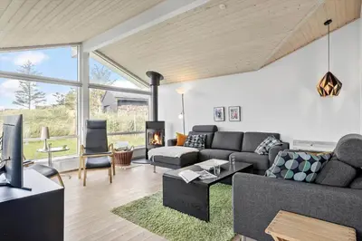 a living room with a couch and a fireplace at BL325-Blokhus-Lyngvej-11 in Blokhus