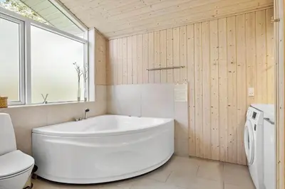 a bathroom with a white tub and a toilet at BL325-Blokhus-Lyngvej-11 in Blokhus