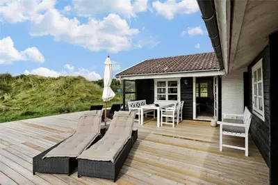 a deck with a table and chairs and an umbrella at BL1665-Saltum-Borgvej-57 in Saltum