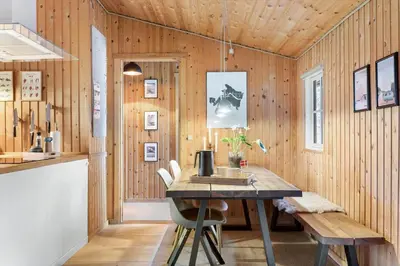 a dining room with wooden walls and a table and chairs at BL1437-Blokhus-Berberisvej-78 in Blokhus