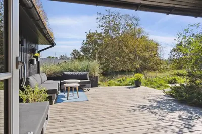 a patio with couches and a table and chairs at BL1437-Blokhus-Berberisvej-78 in Blokhus