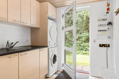 a kitchen with a washer and dryer next to a door at BL127-Saltum-Laustvej-22 in Saltum