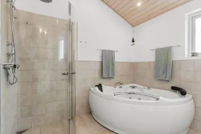 a bathroom with a white tub and a shower at BL127-Saltum-Laustvej-22 in Saltum