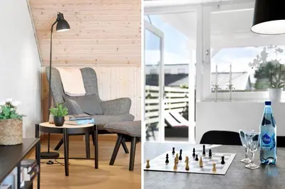 a living room with a chair and a chess board at BL1251-Blokhus-Vigen-9-B in Blokhus