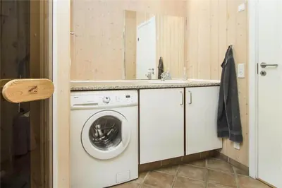 a bathroom with a washing machine and a sink at BL481-Pandrup-Rodhusparken-10 in Pandrup