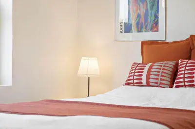 a bed with red and white pillows and a lamp at BL1073-Blokhus-Egonsvej-10 in Blokhus