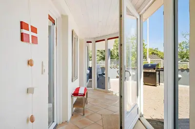 a glass door leading to a patio with a table at BL1073-Blokhus-Egonsvej-10 in Blokhus
