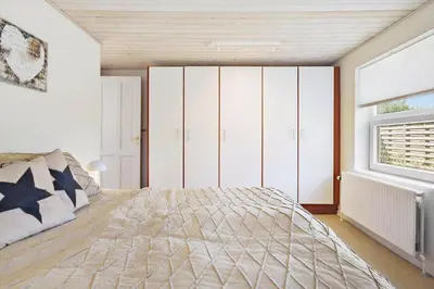 a bedroom with a large bed and a window at BL1073-Blokhus-Egonsvej-10 in Blokhus