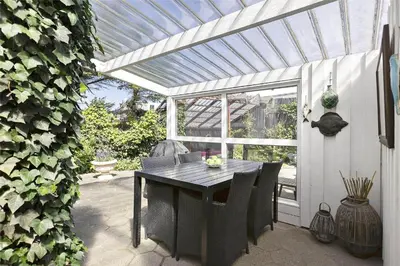 a table and chairs on a patio with a pergola at BL1540-Blokhus-Jens-Baerentsvej-14 in Blokhus