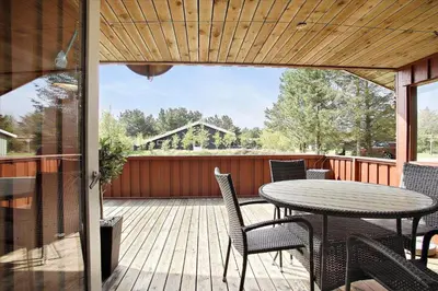 a patio with a table and chairs on a deck at BL1682-Pandrup-Rodhus-Skolevej-24 in Pandrup