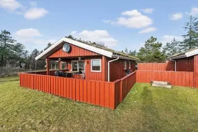 a small red house with a red fence at BL1682-Pandrup-Rodhus-Skolevej-24 in Pandrup
