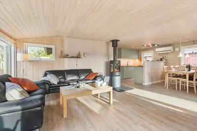 a living room with a black leather couch and a fireplace at BL1682-Pandrup-Rodhus-Skolevej-24 in Pandrup