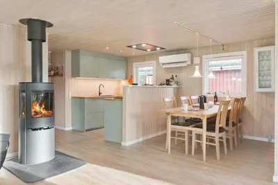 a kitchen and dining room with a woodburning stove at BL1682-Pandrup-Rodhus-Skolevej-24 in Pandrup