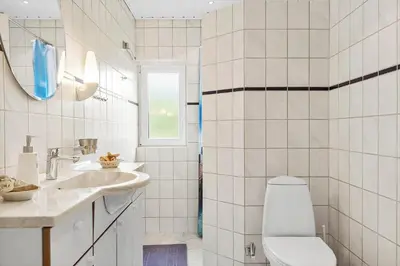 a white bathroom with a toilet and a sink at BL1216-Blokhus-Gyvelvej-13 in Blokhus