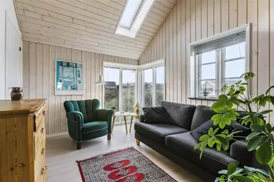 a living room with a couch and a chair at BL964-Blokhus-Klitvejen-28 in Blokhus