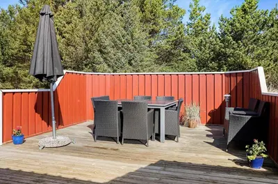 a table and chairs with an umbrella on a deck at BL1600-Saltum-Daadyrvej-25-A in Saltum