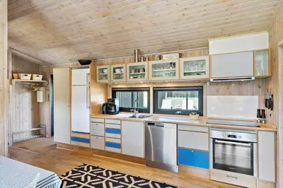 a kitchen with white cabinets and a wooden ceiling at BL1755-Saltum-Karen-Mariesvej-57 in Saltum