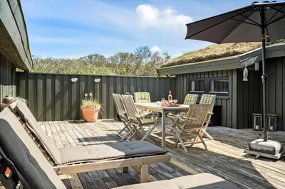 a patio with a table and chairs and an umbrella at BL1755-Saltum-Karen-Mariesvej-57 in Saltum