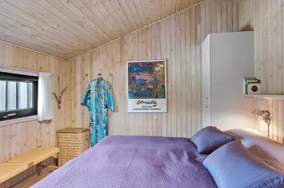 a bedroom with a purple bed in a wooden wall at BL1755-Saltum-Karen-Mariesvej-57 in Saltum
